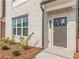 Close up of a front door with modern design and brick and wood trim, set in a landscaped yard at 3409 Catalan Aly, Decatur, GA 30032