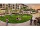 A new construction town square with people socializing on a lush green lawn, and retail in the background at 3409 Catalan Aly, Decatur, GA 30032