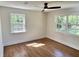 Inviting bedroom with hardwood floors, a modern ceiling fan, and backyard views at 6751 Davidson Ct, Lithonia, GA 30058