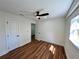 Cozy bedroom featuring hardwood floors, neutral walls, ceiling fan, and natural light at 6751 Davidson Ct, Lithonia, GA 30058