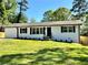 Charming single-story home with manicured lawn and a classic white exterior with black shutters at 6751 Davidson Ct, Lithonia, GA 30058