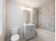 Bathroom with gray vanity, modern lighting, tub with tile surround, and toilet at 4201 Hosch Reserve Dr, Buford, GA 30519
