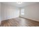 A bedroom featuring laminate flooring, decorative wall panels, and natural light at 4201 Hosch Reserve Dr, Buford, GA 30519