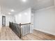 Hallway area with plank flooring, white walls, and a black metal stair railing at 4201 Hosch Reserve Dr, Buford, GA 30519