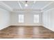 Bright bedroom with light-colored wood floors, a ceiling fan, and elegant wainscoting at 4201 Hosch Reserve Dr, Buford, GA 30519