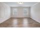 Sunlit bedroom featuring wood floors, wainscoting accents, and two windows at 4201 Hosch Reserve Dr, Buford, GA 30519