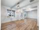 Elegant dining room featuring wood floors, white wainscoting, large windows, and a stylish chandelier at 4201 Hosch Reserve Dr, Buford, GA 30519