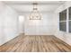 Bright dining room with wood flooring, white wainscoting, a contemporary chandelier, and large windows at 4201 Hosch Reserve Dr, Buford, GA 30519