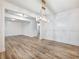 Open-concept dining area with wood floors, white wainscoting, crown molding, and modern lighting at 4201 Hosch Reserve Dr, Buford, GA 30519