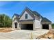 New home with a gray brick exterior, two-car garage, and modern architectural design at 4201 Hosch Reserve Dr, Buford, GA 30519