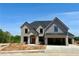 Beautiful new construction featuring a gray brick facade and an attached two-car garage at 4201 Hosch Reserve Dr, Buford, GA 30519