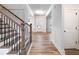 Hallway with wood stairs, white walls and trim, and wood flooring at 4201 Hosch Reserve Dr, Buford, GA 30519