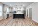 Gourmet kitchen with large island, modern lighting, stainless appliances, custom cabinets and hardwood floors at 4201 Hosch Reserve Dr, Buford, GA 30519