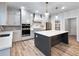 Modern kitchen with island, stainless steel appliances, gas range, and custom range hood at 4201 Hosch Reserve Dr, Buford, GA 30519