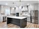 Gourmet kitchen with stainless steel appliances, island, pendant lights, and custom cabinetry at 4201 Hosch Reserve Dr, Buford, GA 30519