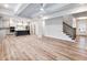 Open-concept living space with hardwood floors, island, and view of kitchen with stainless steel appliances at 4201 Hosch Reserve Dr, Buford, GA 30519
