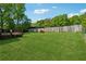A sprawling backyard with a large green lawn, wooden deck, and a partially visible fence at 705 Trickum Valley Dr, Woodstock, GA 30188