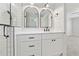Bright bathroom features a shower with white tiling, white cabinets and modern black fixtures at 705 Trickum Valley Dr, Woodstock, GA 30188