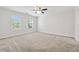 Large bedroom with neutral carpet, a ceiling fan, and two windows at 705 Trickum Valley Dr, Woodstock, GA 30188