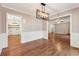 Dining room with hardwood floors and modern light fixture, with views to the living room and utility room at 705 Trickum Valley Dr, Woodstock, GA 30188
