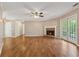 Spacious living room with hardwood floors, a ceiling fan, fireplace, and French doors for seamless indoor-outdoor living at 705 Trickum Valley Dr, Woodstock, GA 30188