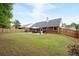 Expansive backyard featuring a patio with outdoor seating, manicured lawn, and a charming privacy fence at 1031 Ludwick Way, Lawrenceville, GA 30046