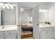 Bright bathroom boasts dual sinks, white cabinets, and an open doorway to the bedroom at 1031 Ludwick Way, Lawrenceville, GA 30046