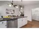 Modern kitchen boasts granite countertops, stainless steel appliances, and an adjacent laundry room at 1031 Ludwick Way, Lawrenceville, GA 30046
