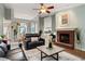 Spacious living room featuring a brick fireplace, hardwood floors, and open access to the dining area at 1031 Ludwick Way, Lawrenceville, GA 30046