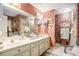 Bathroom with dual sinks, large mirror, cabinet and shelves, and unique decor at 110 Emerald Dr, Mcdonough, GA 30253