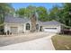 A view of the side of the home showing a stone chimney and manicured front yard at 110 Emerald Dr, Mcdonough, GA 30253