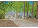 A view of the home on a wooded lot, with a stone chimney and well-kept lawn at 110 Emerald Dr, Mcdonough, GA 30253