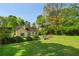 A spacious green backyard with mature shade trees and surrounding shrubbery at 1220 Paddocks Way, Powder Springs, GA 30127