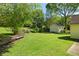 Backyard featuring a lush green lawn, shed, and mature trees at 1220 Paddocks Way, Powder Springs, GA 30127