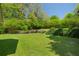 Expansive backyard featuring a lush lawn and mature trees, perfect for outdoor activities and relaxation at 1220 Paddocks Way, Powder Springs, GA 30127