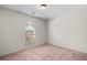 This bedroom offers neutral walls, carpet, and a window for natural light at 1220 Paddocks Way, Powder Springs, GA 30127