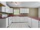 Bright kitchen with white cabinets, white appliances and maroon countertops at 1220 Paddocks Way, Powder Springs, GA 30127