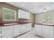 White kitchen with white cabinets, white appliances and maroon countertops at 1220 Paddocks Way, Powder Springs, GA 30127
