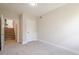 This bedroom has neutral carpet, light paint, and a door leading to the staircase at 128 Partridge Rdg, Woodstock, GA 30188