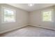 This bright bedroom features neutral walls, plush carpet, and two windows providing natural light at 128 Partridge Rdg, Woodstock, GA 30188