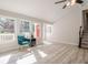 Bright living room features large windows, wood floors, and a modern ceiling fan at 128 Partridge Rdg, Woodstock, GA 30188