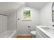 Cozy bathroom under an angled ceiling with tub, shower, vanity, and natural light from the window at 1917 Connally Dr, Atlanta, GA 30344
