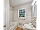 Bathroom with white tiles, a window, and a bathtub at 3137 Ardley Sw Rd, Atlanta, GA 30311