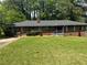 Charming one-story brick home featuring a well-maintained lawn and mature trees providing shade at 3137 Ardley Sw Rd, Atlanta, GA 30311