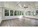 Bright sunroom with laminate flooring, numerous windows offering a beautiful outdoor view, and a ceiling fan at 3137 Ardley Sw Rd, Atlanta, GA 30311