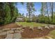 Beautifully landscaped backyard with a lush green lawn, mature trees, and serene seating area at 4220 Club Ne Dr, Atlanta, GA 30319