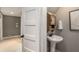 Charming powder room featuring a pedestal sink and classic fixtures, adjacent to a hallway at 4220 Club Ne Dr, Atlanta, GA 30319