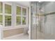 Bright bathroom showcasing modern tile, a glass shower door, and natural light from the shuttered windows at 4220 Club Ne Dr, Atlanta, GA 30319