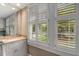 Bright bathroom featuring white cabinets, granite counters, a large mirror, and plantation shutters for natural light at 4220 Club Ne Dr, Atlanta, GA 30319
