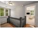 Upstairs hallway featuring hardwood floors, gray walls, and an open doorway to a bedroom with a comfortable sitting chair at 4220 Club Ne Dr, Atlanta, GA 30319
